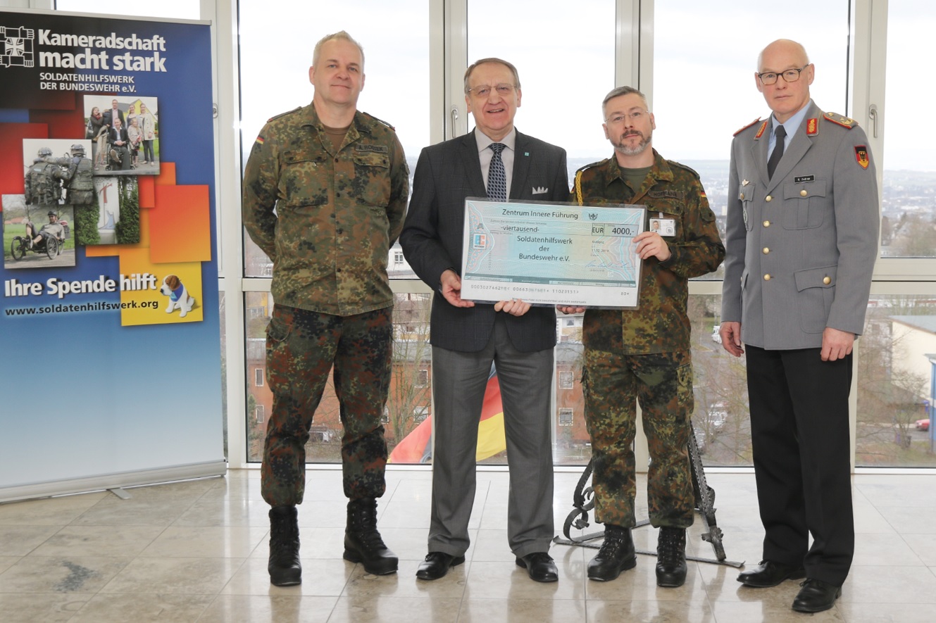 General Zudrop, Stabsfeldwebel Hofmann, Herr Ketterle und Oberstabsfeldwebel Rostek bei der Scheckübergabe.