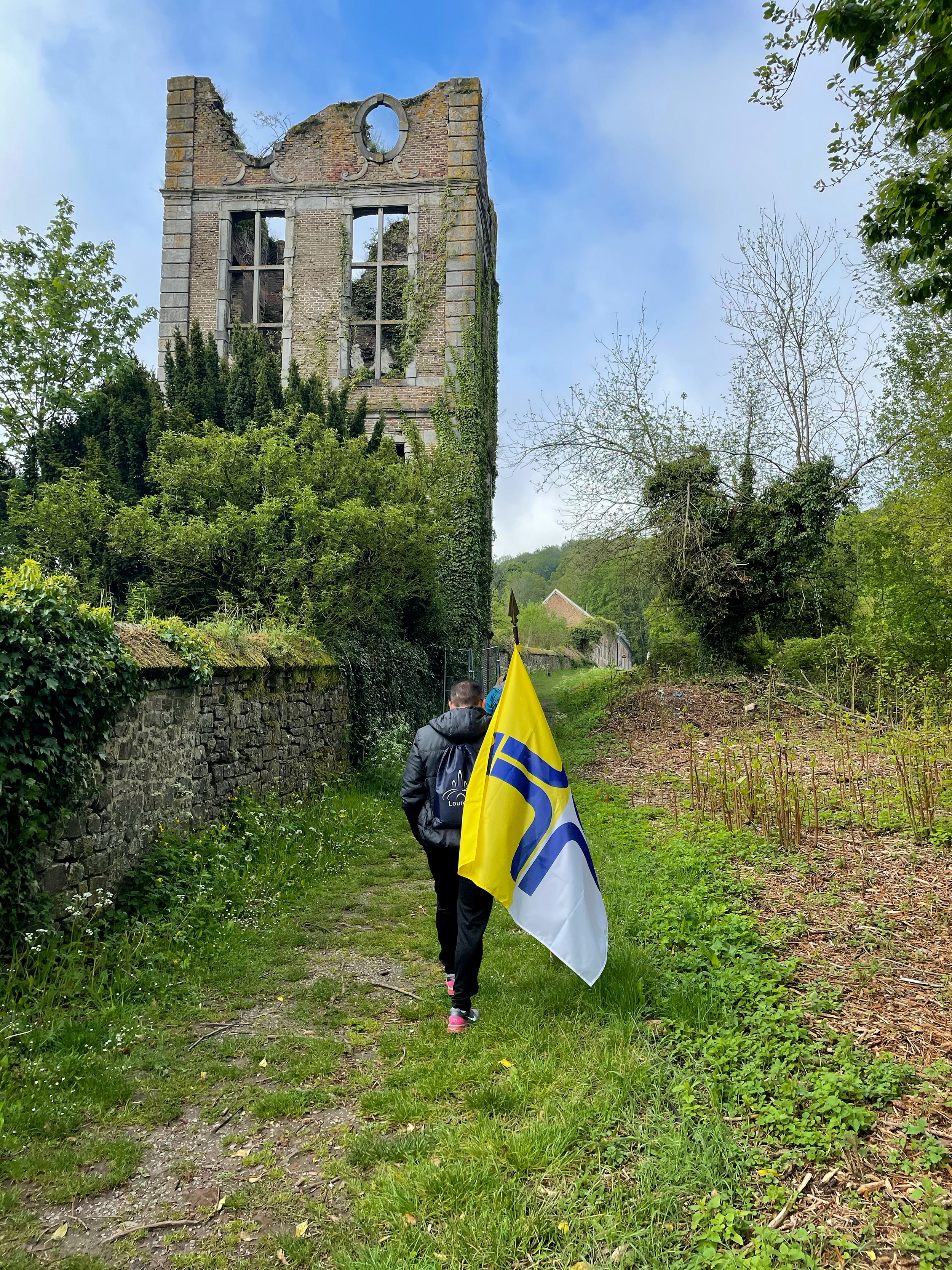 Pilger mit der Fahne der Militärseelsorge an der Klosterruine Abbaye d´Aulne