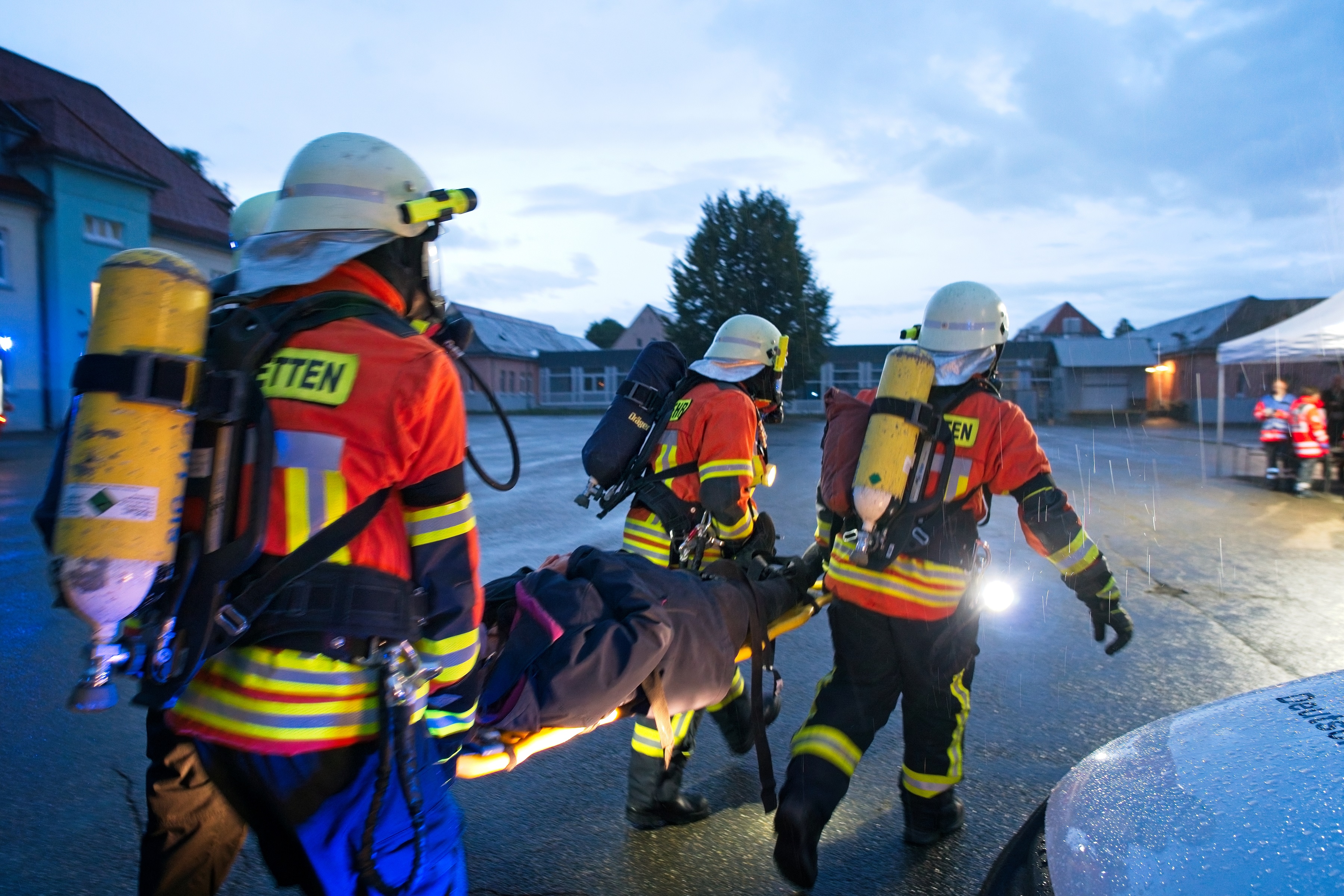 4 Feuerwehrleute tragen eine verletzte Person auf einer Trage