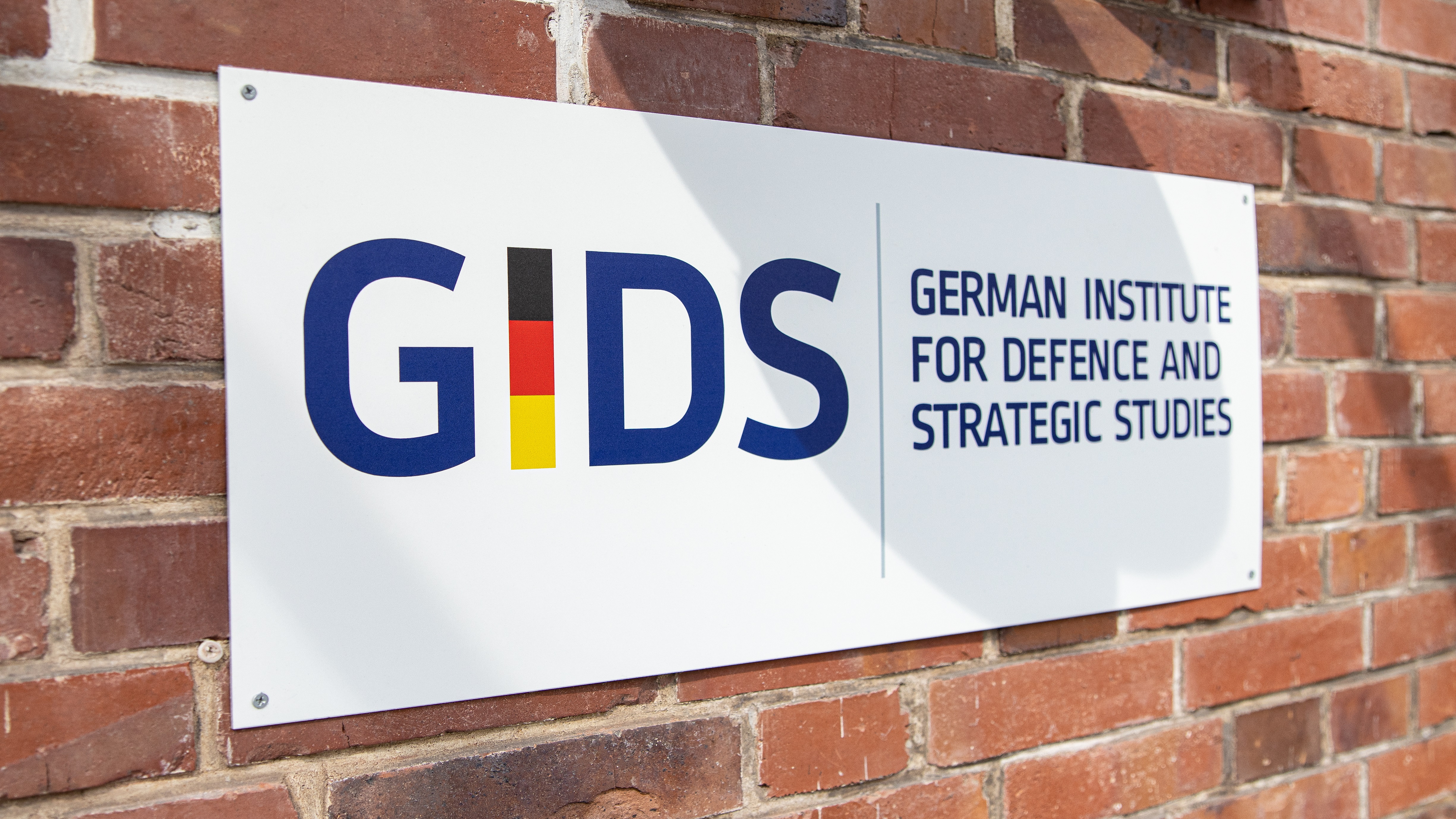 Schild mit dem Logo des GIDS Schriftzug, bunte Schrift auf weißen Hintergrund