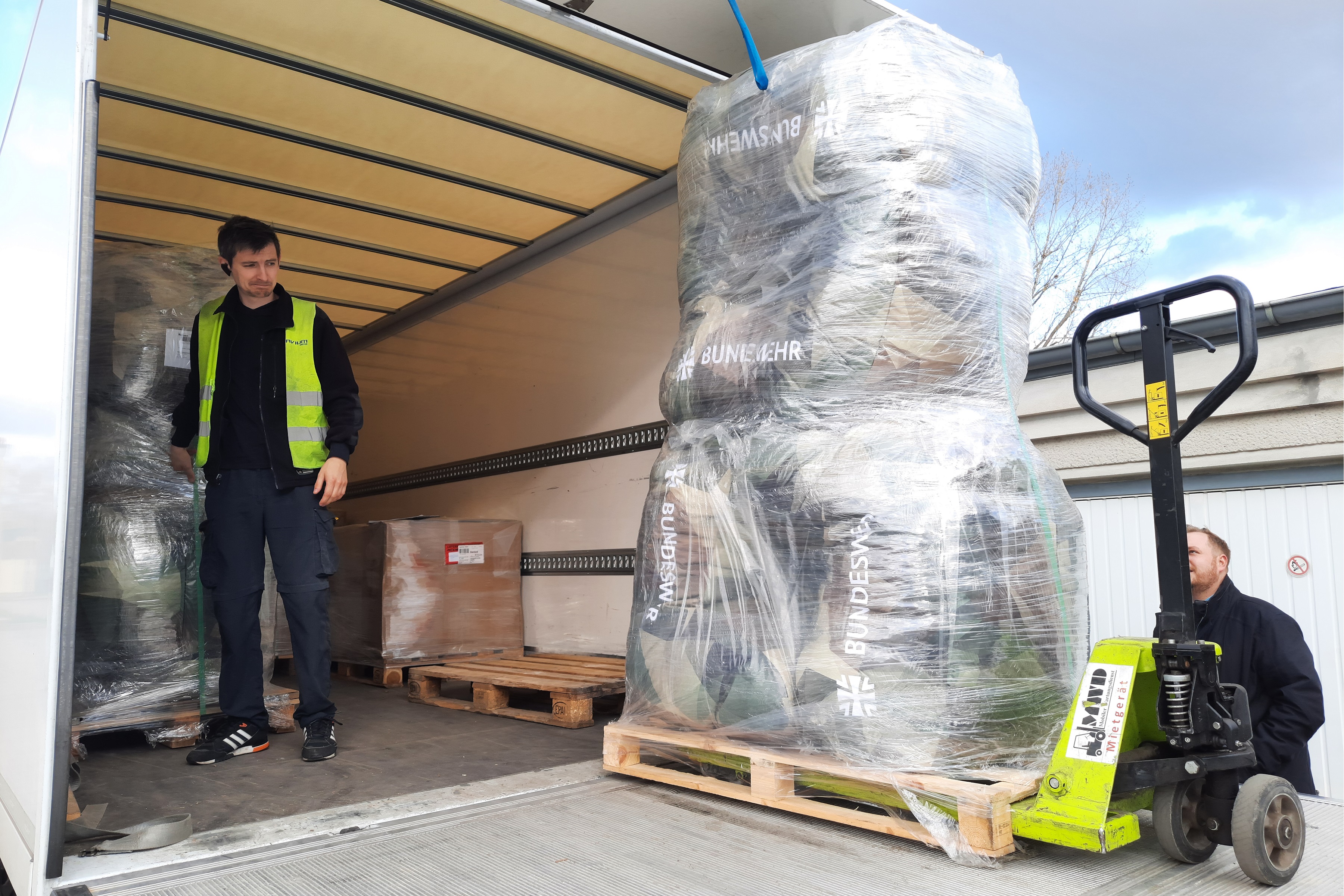 Laderaum eines Lastwagens, über die Laderampe werden Möbel ausgeladen