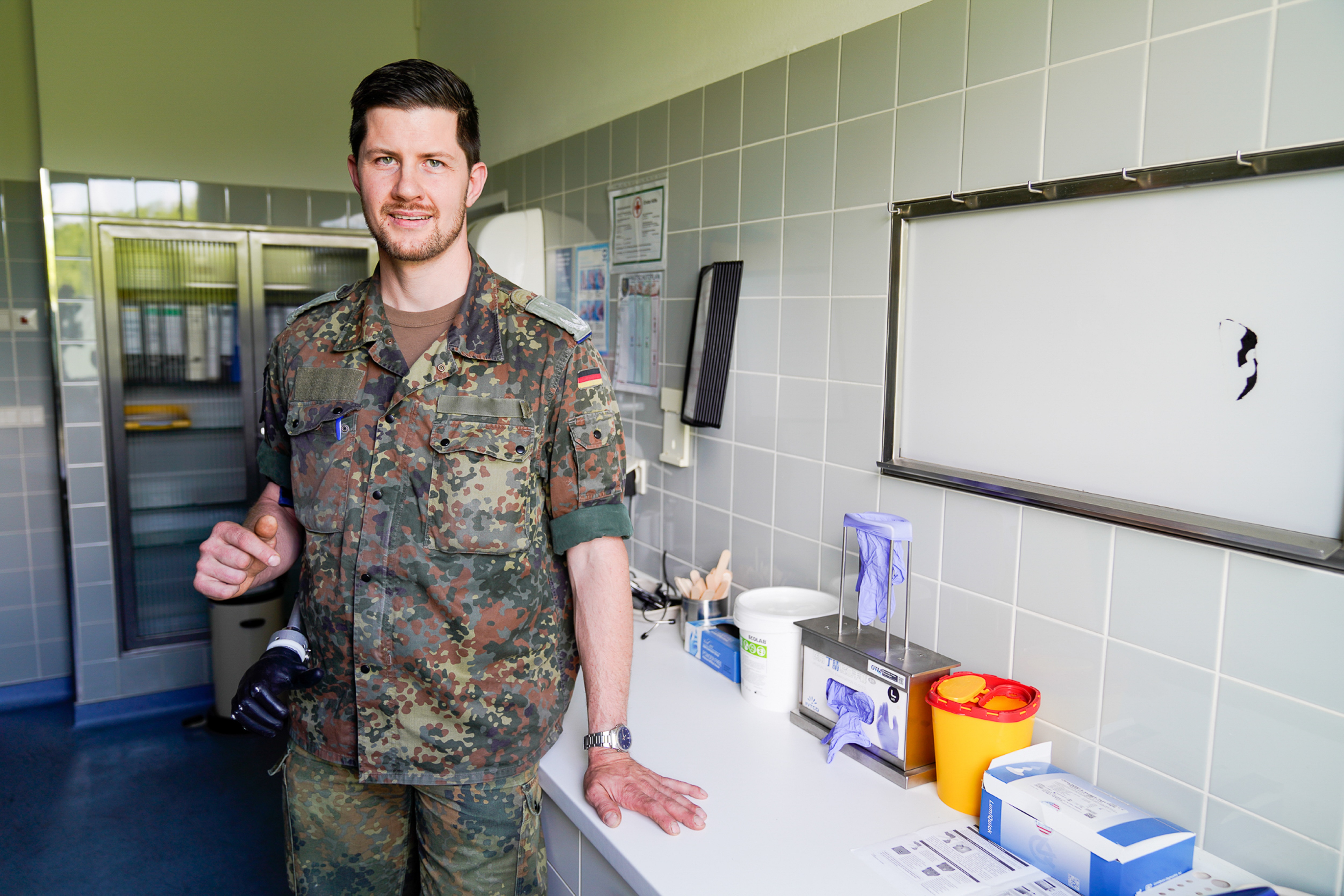 Ein Soldat steht in einem Untersuchungsraum und schaut in die Kamera.