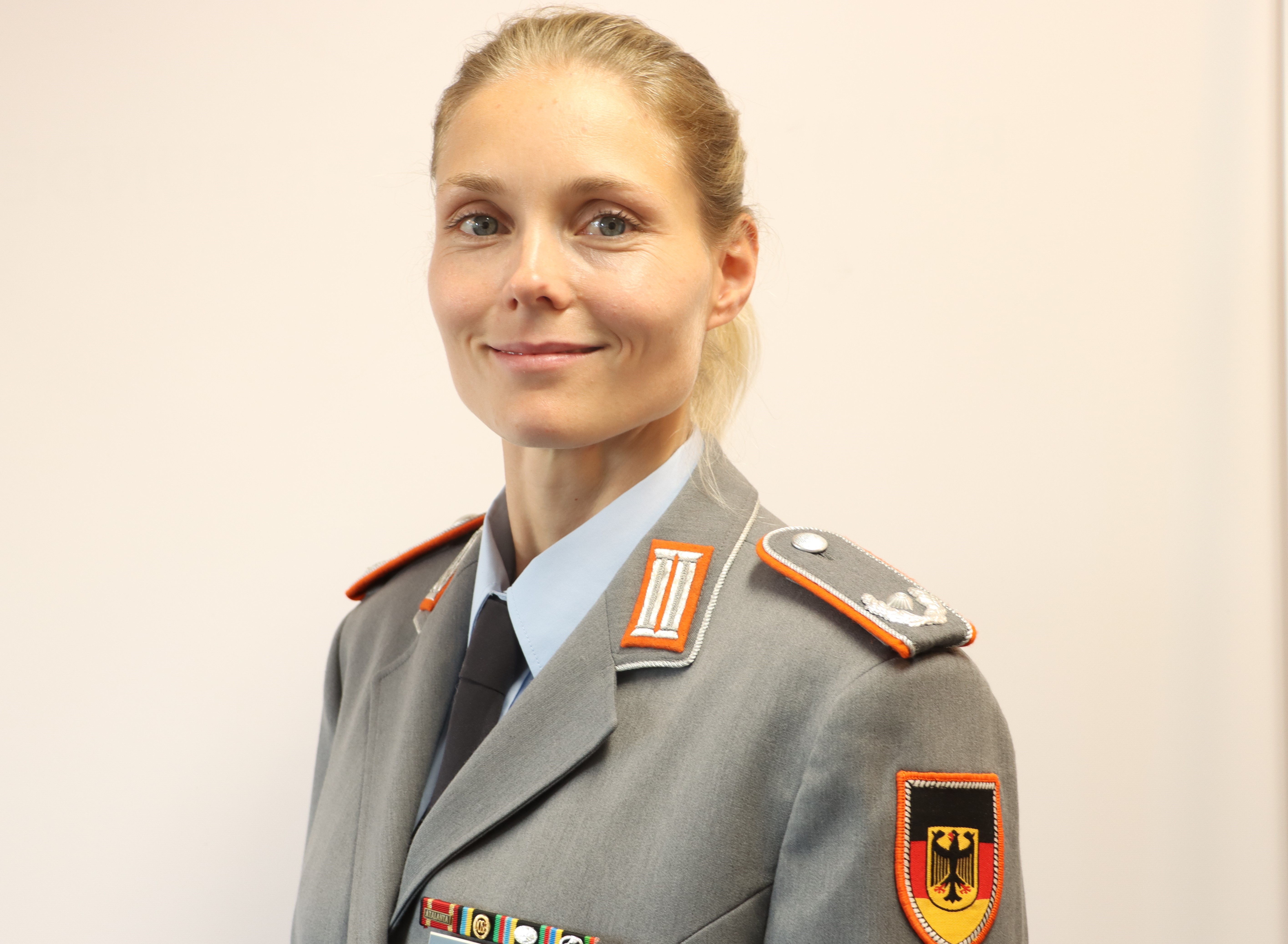 Eine blonde Frau vom Dienstgrad Major ohne Kopfbedeckung im Dienstanzug