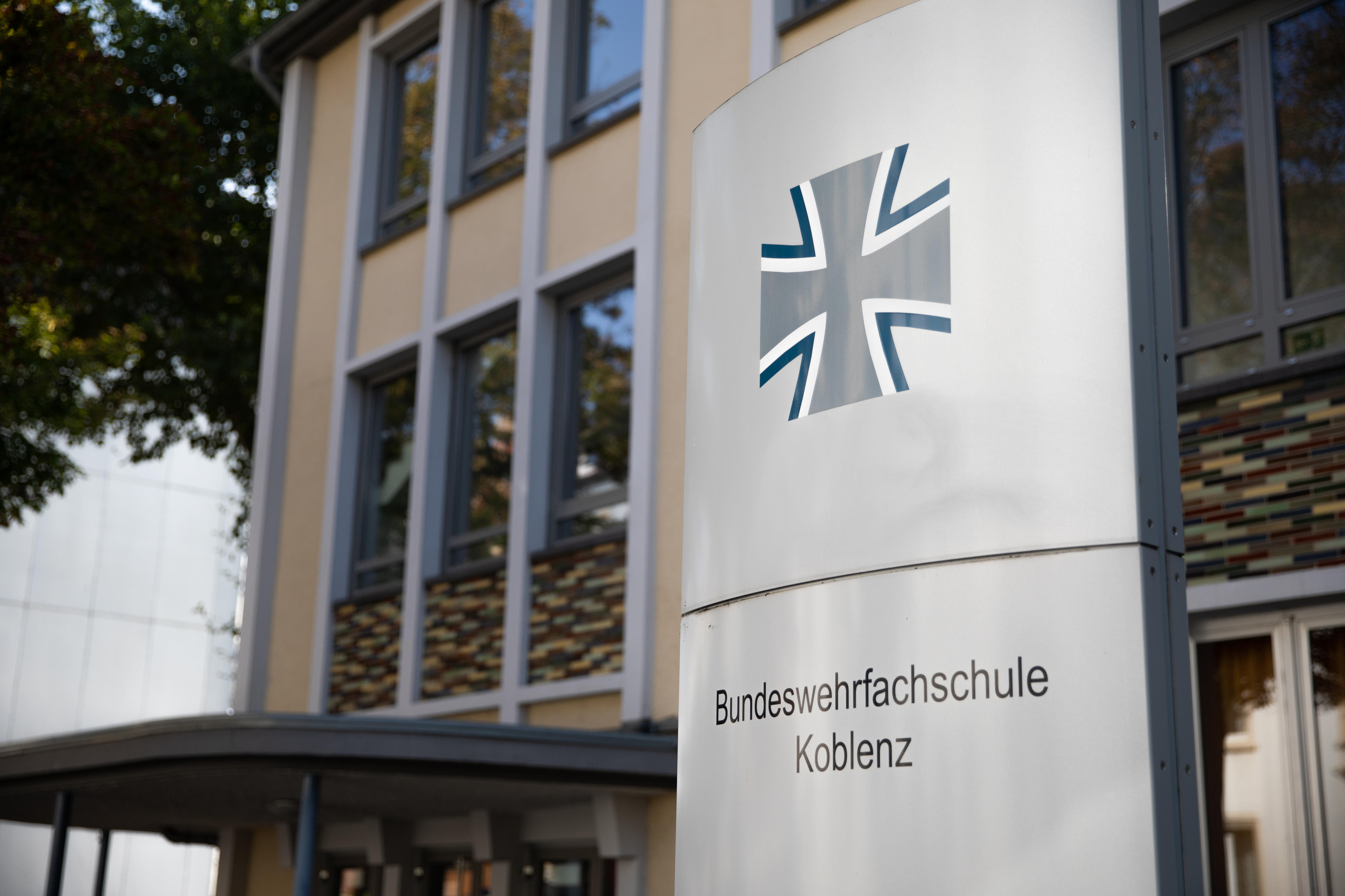 Eine Metallsäule mit Beschriftung steht vor einem Gebäude.