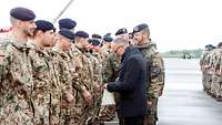Militärseelsorger Bernhard Jacobi holt aus einer Tüte kleine Schutzengel undüberreicht jedem Soldaten einen.