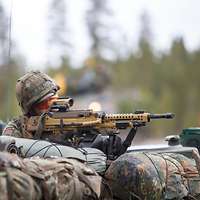 Ein Soldat beobachtet aus einem Schützenpanzer heraus das Gelände durch das Visier eines Maschinengewehrs.