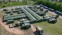 Das Rettungszentrum der Bundeswehr aus der Vogelperspektive Parallel verlaufende grüne Zelte, an denen mehrere grüne Container mit Rotem Kreuz angeschlossen sind.