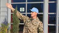 Soldat mit blauem Basecap zeigt in eine Richtung