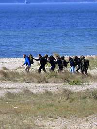 Soldaten evakuieren Zivilisten an einem Ufer