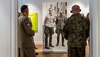 Ein deutscher und polnischer Soldat sehen sich in der Gedenkstätte eine lebensgroße Schautafel an.