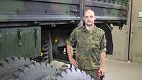 Ein Soldat steht neben einm LKW