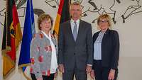 Gruppenbild mit zwei weiblichen und einer männlichen Person in einem Festsaal