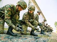 Fahnenjunker während der Waffenausbildung Soldaten knien in einer Reihe auf dem Rasen während der Waffenausbildung