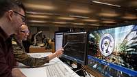 Menschen arbeiten vor einem Monitor.