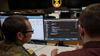 Menschen arbeiten an Monitoren.