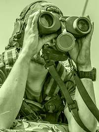 Ein Soldat der Heeresaufklärungstruppe beobachtet das Gelände Ein Soldat schaut mit einem Fernglas aus einem Fahrzeug.