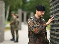 Gedenken im „Wald der Erinnerung“ Ein Soldat berührt eine Namensstele im „Wald der Erinnerung“.