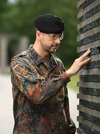 Ein Soldat berührt eine Namensstele im „Wald der Erinnerung“.