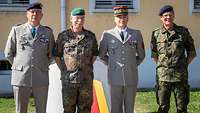 Vier Generale stehen nebeneinander im Sonnenschein.