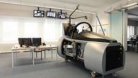 Der Cockpit-Simulator ist quasi eine große verkabelte "Metallkiste" auf Rädern, die in einem normalen Büro steht.