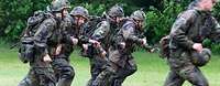 Soldatinnen und Soldaten rennen über eine Wiese