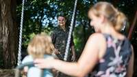 PTBS erkrankter Soldat mit Frau und Kind auf dem Spielplatz