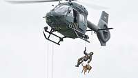 Soldat mit Hund seilt sich aus einem H145M ab.