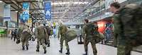 Ankunft Soldaten am Flughafen Mehrere Soldaten in Flecktarn Uniformmit Gepäck betreten die Halle eines Flughafens.