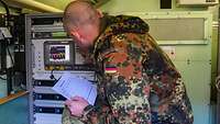Soldat prüft auf einem Monitor Einstellungen.