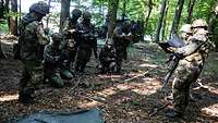 Soldaten stehen vor einem Geländesandkasten