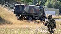 Ein Soldaten sperrt einen Bereich ab, während ein Andere sichert