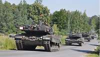 Eine Kolonne von Panzern fährt auf der Straße