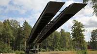 Ein Panzer fährt eine sehr lange Brücke uns 