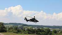 Der UH Tiger steigt auf Ein Hubschrauber des Typs Tiger schwebt über deiner Landschaft vor weiss-blauem Himmel