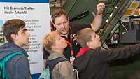 Klaus Maicher erklärt jungen Besuchern auf IdeenExpo Technik im Transportpanzer