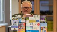 Ein Reservist steht hinter einem Aufsteller mit Flyern. Themenbereiche sind Kultur, Aktivitäten, Informationen für Reservisten.