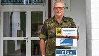 Ein Reservist steht vor dem Eingangsbereich Unterstützungspersonal Standortältester, Betreuungsbüro und Info Bundeswehr.