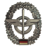 Ovales Zeichen, mittig ein Flügelstab vor einem Rad, Eichenlaub, unten eine Deutschlandfahne