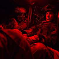 Blick in das Innere eines Schützenpanzers Puma: Eine Besatzung sitzt unter rotem Licht.