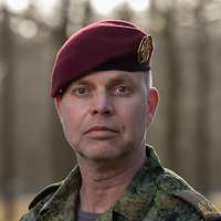 Ein Soldat mit einem roten Barett schaut in die Kamera.