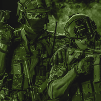 Zwei Soldaten stehen mit der Waffe im Anschlag in einem dunklen Raum.