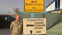 Ein Soldat steht neben dem Stadtschild Murnaus sowie einem Wegweiserschild, das auf die „Support Coy“ verweist 