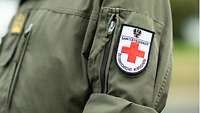 Ein Patch mit rotem Kreuz, der Aufschrift Sanitätsdienst und dem Österreichischen Bundesadler, auf einer Uniform 