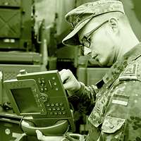 Zwei Soldaten bereiten Telefone für den Einsatz in einem Gefechtsstand vor.