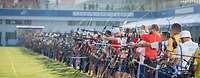 Viele Bogenschützen stehen in einem Stadion nebeneinander.