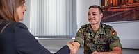 Der erste Schritt. Der Weg zur Reserve. Ein Reservist sitzt Hände schüttelnt am Tisch
