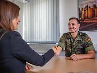Der erste Schritt. Der Weg zur Reserve. Ein Reservist sitzt Hände schüttelnt am Tisch