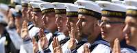 Auftrag der Marine Marinesoldaten in Matrosenuniform, in Reihe angetreten, heben die Hand, um einen Eid zu schwören.