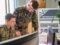 Zwei Soldaten im Betreuungsbüro sichten Angebote