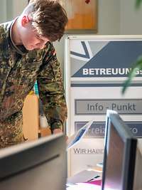 Betreuungsportal Zwei Soldaten im Betreuungsbüro sichten Angebote